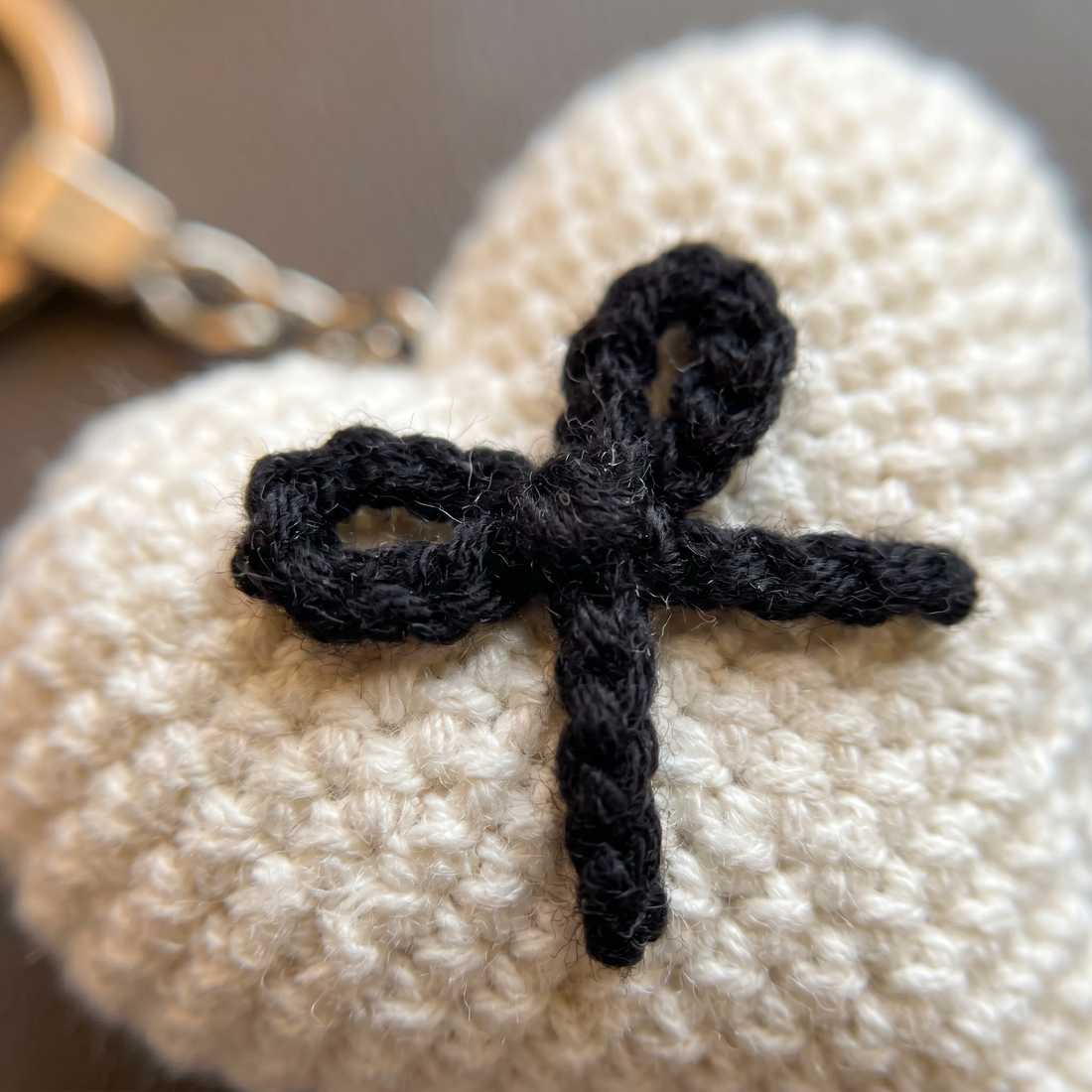 ميدالية كروشيه قلب أبيض بفيونكة سوداء – صناعة يدوية من Berry Bow